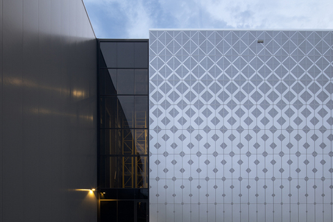 Photo de la jonction vitrée entre le bâtiment existant et la nouvelle façade au motif géométrique de l'entrepôt de Browns, à Saint-Laurent, Montréal.
